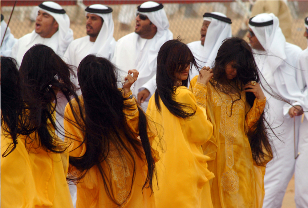 Young girls participating in Al-Razfa, dancing and swinging their long hair in tune to the strong beat of music, UAE