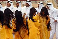 Young girls participating in Al-Razfa, dancing and swinging their long hair in tune to the strong beat of music, UAE