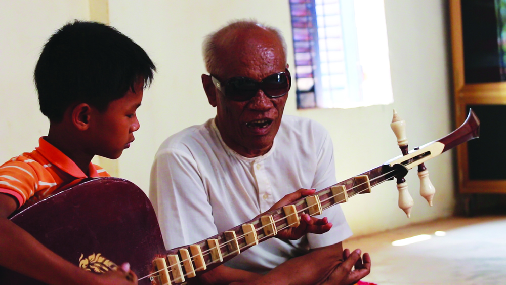 The master Kong Nai teaches his grandson how to play the Chapeai Dang Veng at his house, Kampot province