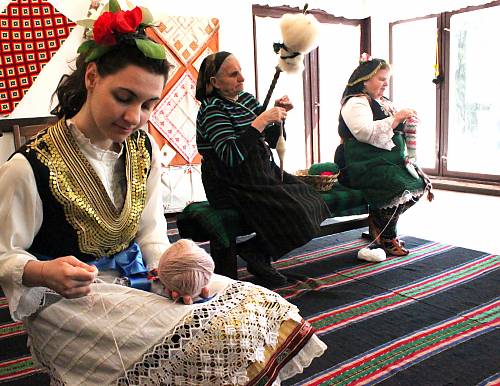 La joven Ivelina Georgieva trabaja con Stefka Zasheva, que sostiene una rueca, y Petruna Pashova. El hilado y el tejido con fibras de hilo es una artesanía local tradicional practicada principalmente por mujeres.