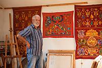 Mamut Churlu, the leader of 'Chatyr Dag' informal cultural association, in his artist's studio presenting embroidered panels based on Ornek ornaments 