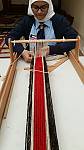 A young female student from a public school in Kuwait training on the traditional Al Sadu weaving loom