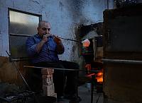 Master Craftsman, Ahmad Hallaq blows the molten glass so it can inflate and take shape